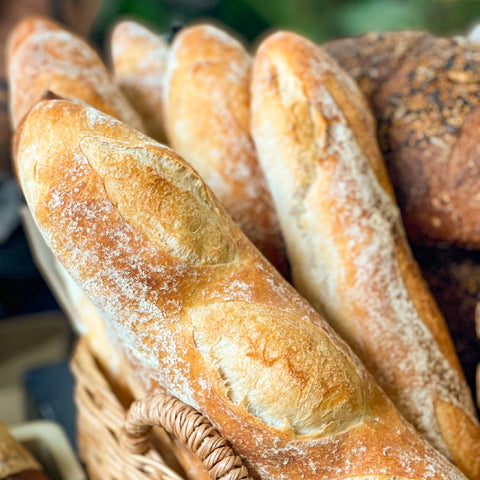 Freshly baked authentic French baguettes with a golden crust and soft, airy interior, crafted by Chef Nir Netzer